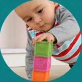 A baby stacking coloured blocks
